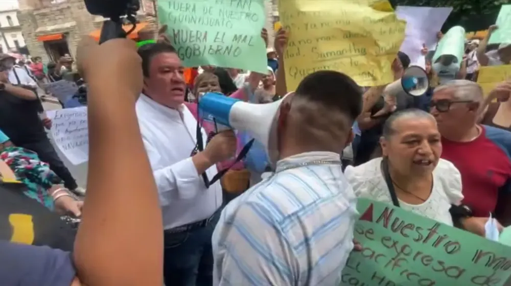 Jorge Rodríguez Medrano agrede ciudadano El conductor de TV8, Jorge Rodríguez Medrano, agrede con un megáfono a un ciudadano que trata de pasar entre los manifestantes. Foto tomada del video del hecho.