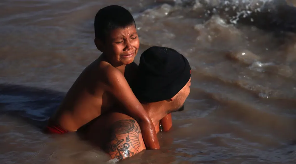 Niño y su padre cruzando el Río Bravo